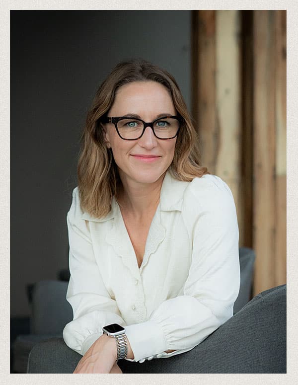 Founder of Castle's Rock's Velvet Fern Creative headshot. She is sitting on a chair with a cream blouse smiling at the camera.